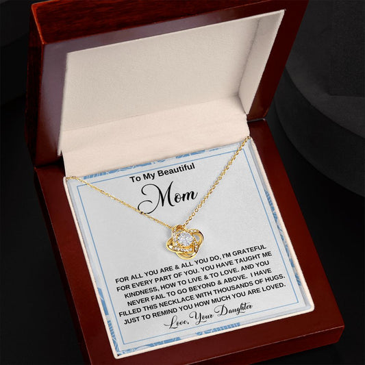 Love Knot Necklace - A perfect gift for your beautiful mom, symbolizing an unbreakable bond with premium cubic zirconia crystals. Crafted in 14k white gold or 18k yellow gold over stainless steel. Features a 6mm round cut cubic zirconia stone. Adjustable chain length for a perfect fit. Packaged in a complimentary soft-touch box or upgrade to the mahogany-style luxury box with LED spotlight.